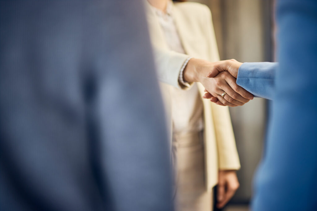 focus on the two business females, shaking hands after the meeting.